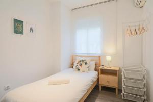 a small bedroom with a bed and a night stand at Lofty Justa in Seville