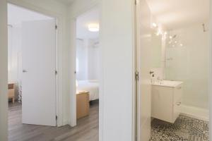 a white bathroom with a sink and a mirror at Lofty Justa in Seville