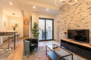 a living room with a tv and a brick wall at Fasquel Center in Seville