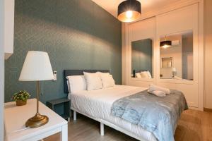 a bedroom with a bed with a lamp and a mirror at Fasquel Center in Seville
