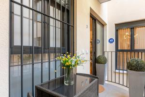 a vase with yellow flowers on a table in front of a building at Fasquel Center in Seville