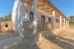 a white house with blue doors and a fence at Casa Da Ti Vanda in Zambujeiras