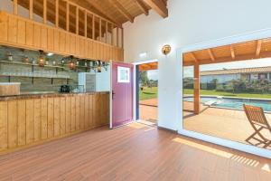a kitchen with a pink door leading to a patio at Casa Da Ti Vanda in Zambujeiras