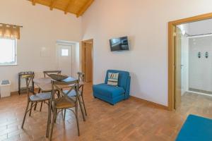 a living room with a table and a blue chair at Casa Da Ti Vanda in Zambujeiras