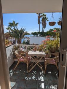 een terras met een tafel en stoelen op een balkon bij Modern & Spacious Studio Isla, Puerto Del Carmen in Tías
