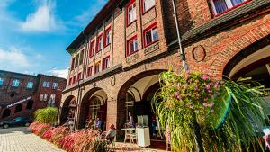 a brick building with flowers on the side of it at Zacisze Pod Nikiszem in Katowice