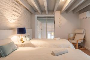 Un dormitorio con dos camas y una silla. en Orbyz, en Sevilla