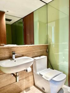 a bathroom with a sink and a toilet and a mirror at Sky Suites KLCC Glorious in Kuala Lumpur