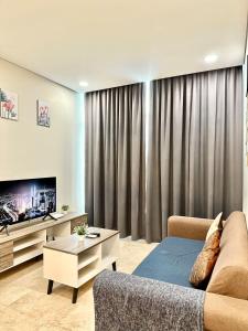 a living room with a couch and a tv at Sky Suites KLCC Glorious in Kuala Lumpur