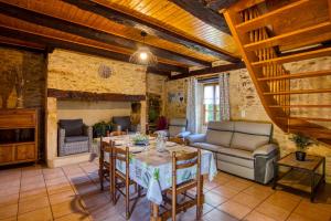 ein Wohnzimmer mit Tisch und Couch in der Unterkunft GITE LES PIERRES CHAUDES in Veyrignac