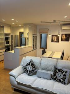 a living room with a white couch and a kitchen at Aki House in Tokyo