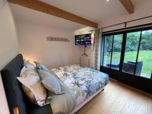 a bedroom with a bed and a large window at Le P’tit Bois Doré in Blanquefort