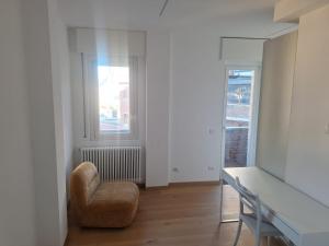 a living room with a chair and a desk at Bovara 49 in Lecco
