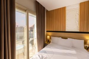 a bedroom with a bed and a large window at Taj Pyramids View Hotel & Suites in Cairo