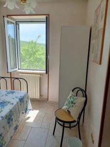a room with a bed and a chair and a window at Casa Bea in Castiglione