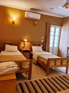 a hotel room with two beds and a window at Kareem Hotel Luxor in Luxor