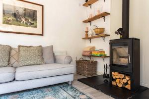 WoolvertonにあるThe Cowshed - Country Retreatのソファと暖炉のあるリビングルーム