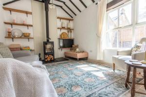 WoolvertonにあるThe Cowshed - Country Retreatのソファと暖炉のあるリビングルーム