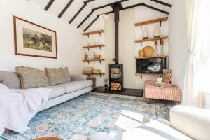 WoolvertonにあるThe Cowshed - Country Retreatのソファと暖炉のあるリビングルーム