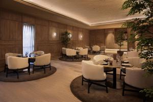 een eetkamer met tafels en witte stoelen bij MIM Baqueira Member of Melia Collection in Baqueira-Beret