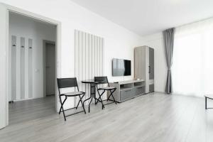 a white room with chairs and a table and a television at Hori Residence - Confort și Stil în Băile Felix in Cordău