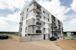 a white building with cars parked in front of it at Hori Residence - Confort și Stil în Băile Felix in Cordău
