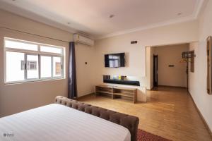 een slaapkamer met een bed en een raam bij Nouveau Hotel in Accra