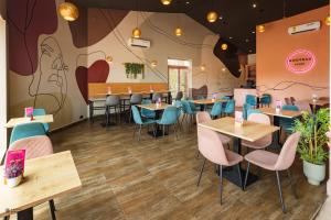 een restaurant met tafels en stoelen en een muurschildering bij Nouveau Hotel in Accra