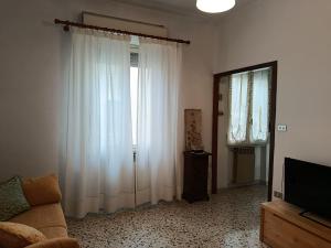 a living room with white curtains and a television at La Villetta in Vittorito