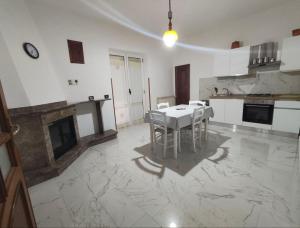 a white kitchen with a table and a fireplace at Guesthouse Matese in Piedimonte dʼAlife