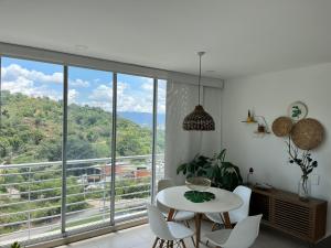 ein Raum mit Tisch und Stühlen und einem großen Fenster in der Unterkunft Suites con Vista en Floridablanca in Floridablanca