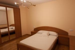 Dormitorio pequeño con cama y espejo en Apartamentos Río Guadalaviar, en Albarracín