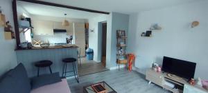 a living room with a couch and a kitchen at appt F3 - La Bresse/Cornimont in Cornimont