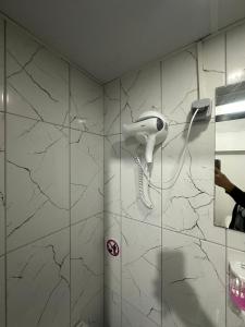 a white hairdryer on a wall in a bathroom at NR1 Pansiyon in Canakkale