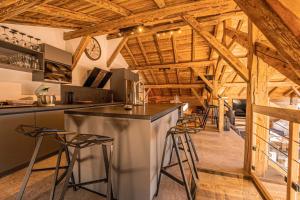 eine Küche mit Holzdecken und eine Bar mit Hockern in der Unterkunft Chalet Louisette luxe, Bain Nordique, 3 Vallées -Navette privée in Saint-Jean-de-Belleville