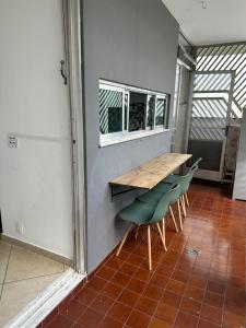 a room with a wooden table and green chairs at Quartos Vila Olímpia 1 in Sao Paulo +29 photos