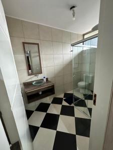 a bathroom with a black and white checkered floor at Quartos Vila Olímpia 1 in Sao Paulo