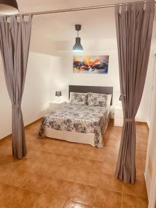 ein Schlafzimmer mit einem Bett und zwei Vorhängen in der Unterkunft Vv Ancla in Puerto de Mogán