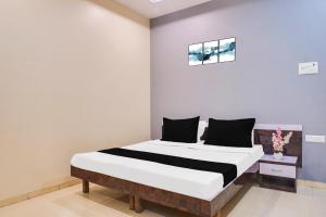 a bedroom with a large bed in a room at Hotel O Atithi Lodge in Wagholi