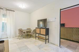 a living room with a table and a tv in a room at San Clemente House in Seville