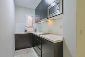 a kitchen with a sink and a microwave at San Clemente House in Seville