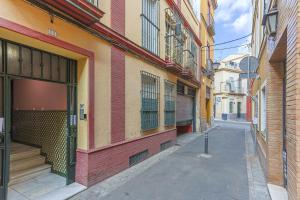 an empty alley in a city with buildings at San Clemente House in Seville +84 photos