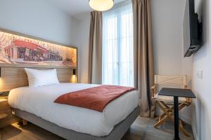 ブローニュ・ビヤンクールにあるDantan Hôtelのベッドと窓のあるホテルの部屋