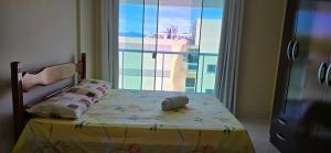 een slaapkamer met een bed en een groot raam bij Triplex Penthouse with Private Pool and Sea View in Rio das Ostras