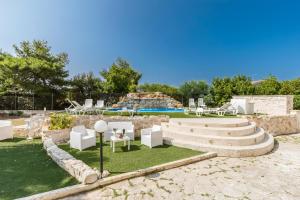 a garden with chairs and tables and a pool at La Villa Alba by BarbarHouse in Leporano Marina