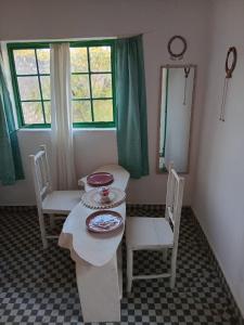 a table and chairs in a room with a window at Tango house in Ukunda