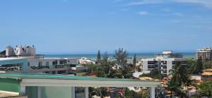 uitzicht op een stad met gebouwen en de oceaan bij Triplex Penthouse with Private Pool and Sea View in Rio das Ostras