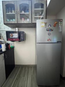 cocina con nevera con imanes y armarios en Homely, Secured, Privacy at Prime Location, en Vadodara 3 fotos más