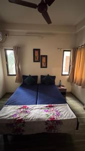 Un dormitorio con una cama azul con flores. en Homely, Secured, Privacy at Prime Location, en Vadodara