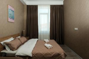 a bedroom with a bed with towels on it at HD Didveli Apartment in Bakuriani